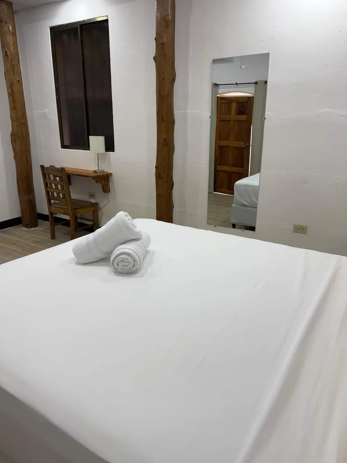 Suite 1 — cama doble entre rústicos postes de madera