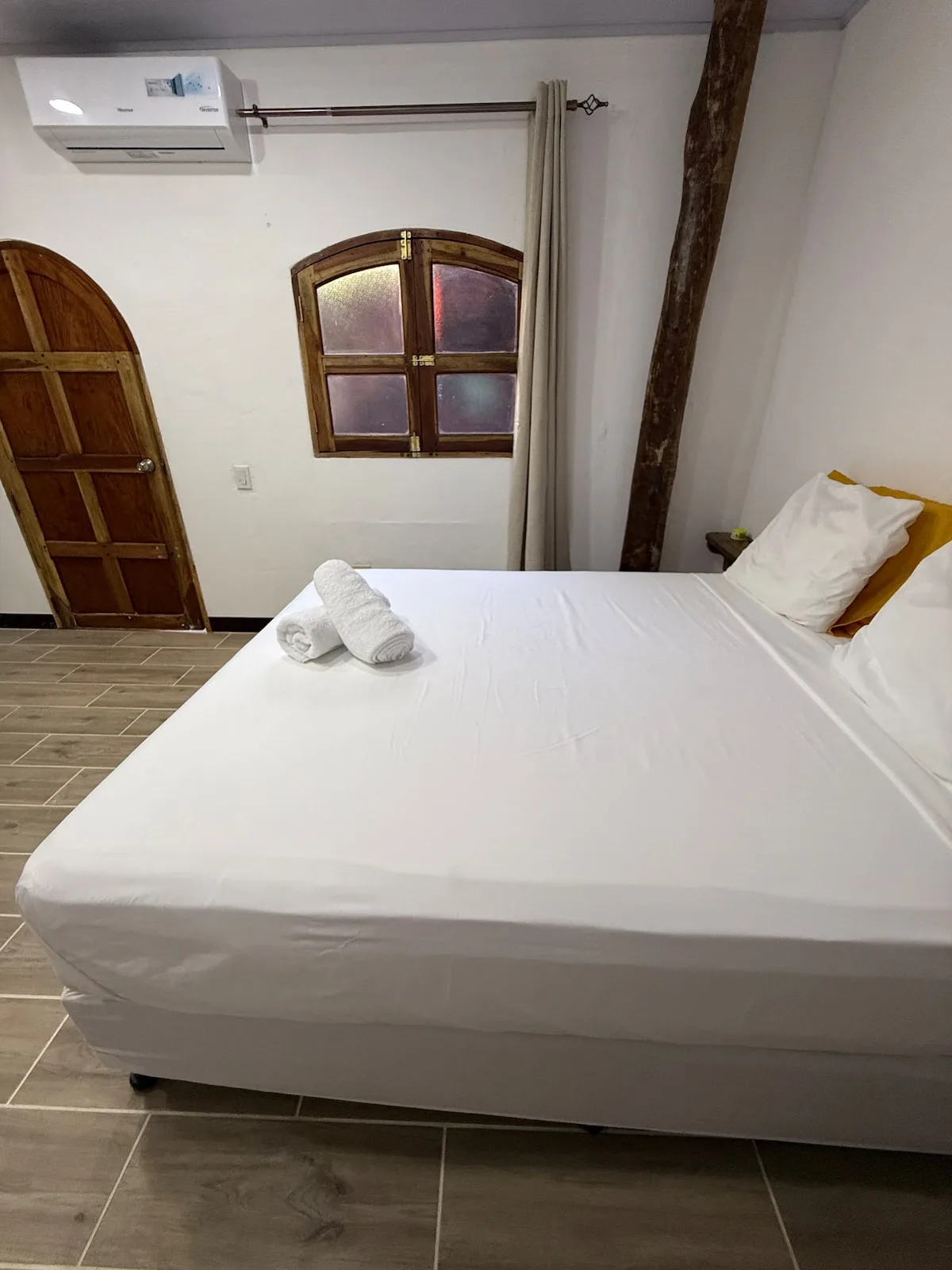 Suite 2 — cama queen junto a una ventana de arco